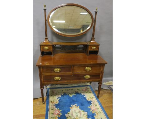 AN EDWARDIAN MAHOGANY MARQUETRY INLAID DRESSING TABLE, the raised superstructure containing an oval bevelled plate between co