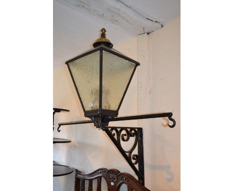 Early 20th Century wrought iron black painted wall lantern with scroll work wall bracket and two hooked hanging arms with bra