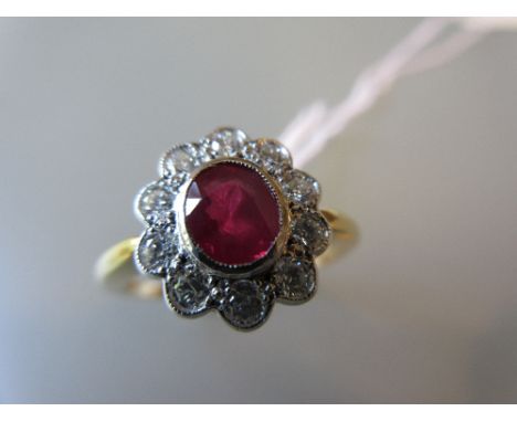 Oval cluster ring set with a central ruby within a diamond surround