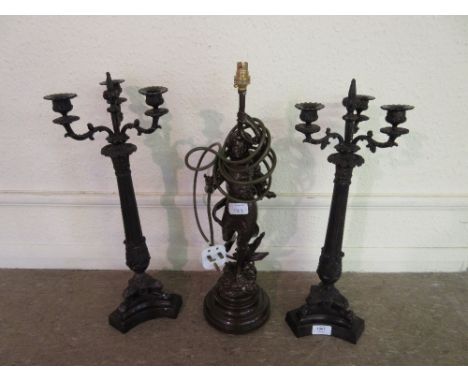 Pair of Regency style dark patinated three light candelabra on lions paw tripod bases with integral plinths, together with a 