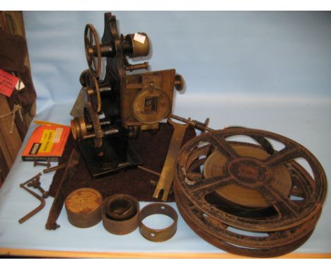 Early 20th Century film projector together with a quantity of rolls of film etc