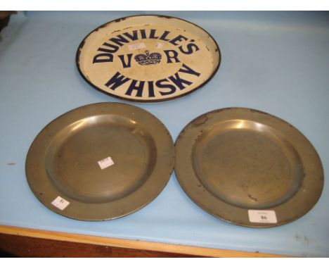 Pair of small antique pewter plates, an Art Deco composition wall plaque and a whisky advertising tray 