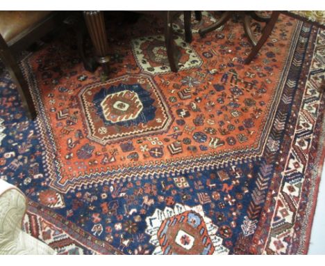 South West Persian style carpet with quadruple medallion and all-over stylised design on a red ground with blue corner design