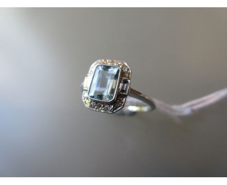 Art Deco style ring set rectangular aquamarine flanked by two small baguette diamonds and further diamond surround