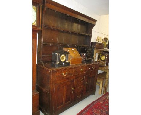 George III oak dresser with boarded shelf back above four centre drawers flanked by two further drawers and two panel doors w