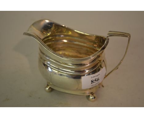 George III London silver helmet shaped cream jug with engraved monogram on low ball supports, dated 1815
