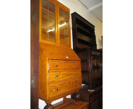 Light oak bureau bookcase circa 1930 with two glazed doors above a fall front and drawers on baluster supports