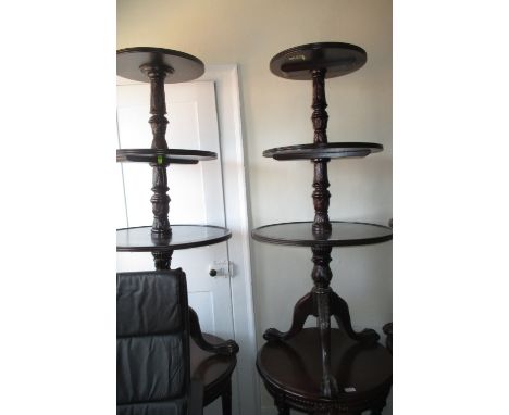 Pair of reproduction circular mahogany three tier dumb waiters on carved column and tripod claw and ball supports