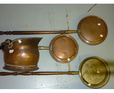 Copper helmet shaped coal scuttle with swing handle and three copper and brass bed warming pans with ebonised and turned wood