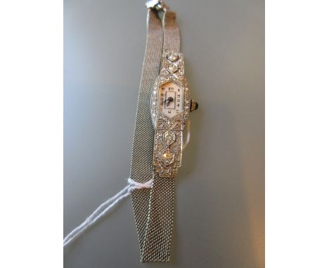 Art Deco platinum diamond set cocktail watch with cabochon sapphire inset winder and a platinum adjustable bracelet strap