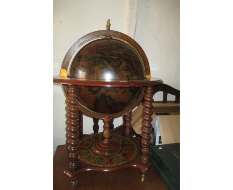 20th Century cocktail cabinet in the form of a globe having hinged top section with partially fitted interior on barley twist