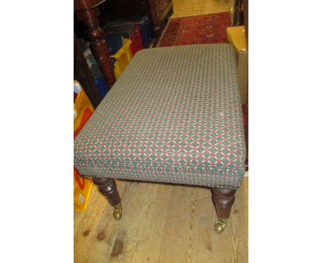 Reproduction mahogany and upholstered rectangular stool on turned supports with brass casters