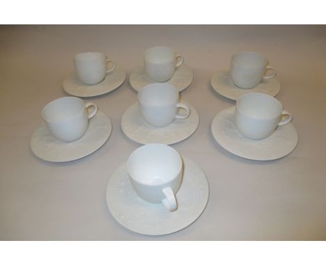 Bjorn Wiinblad for Rosenthal, set of seven porcelain coffee cups and saucers, the saucers with figural relief moulded decorat