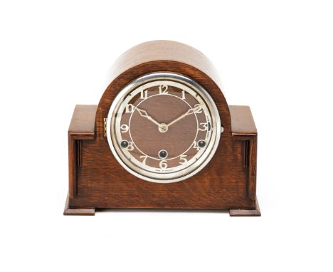 AN OAK CASED MANTLE CLOCK
of arched form and metallic dial with 'made in England' inscribed to the face, key present
23cm x 2