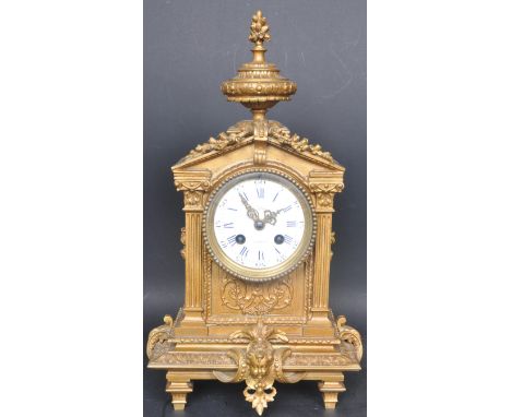 A 19th century French Neoclassical gilt on brass mantle clock of architectural form. The clock having a flower finial over pe