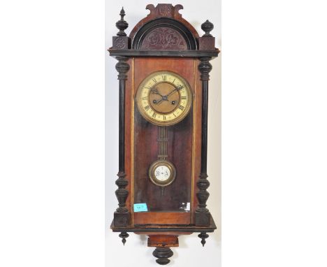 A 19th century Victorian Vienna Regulator wall hanging clock having an ebonised domed top flanked by finials, white enamel cl