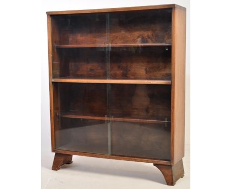 A retro vintage mid 20th century circa 1960s Herbert Gibbs dark teak bookcase having a two sets of sliding glazed doors openi