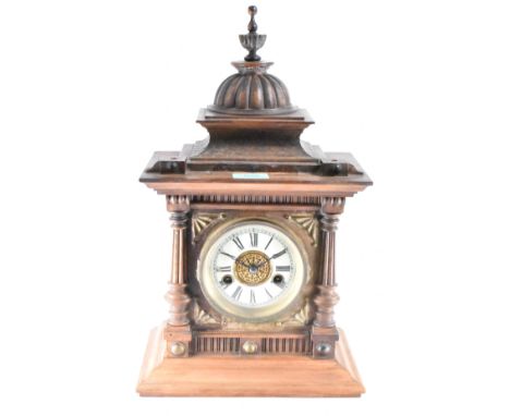 An early 20th century Edwardian circa 1910 oak cased mantel clock having a finial spire atop a gadrooned dome, flared top, pi