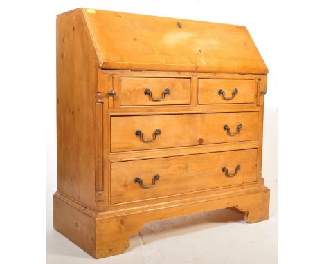 A 20th century country pine bureau having a fall front with fully appointed upon a bank of two over two drawers flanked by re