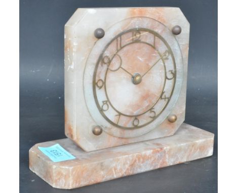 A 1950s Art Deco alabaster mantel clock, standing on a rectangle base, having brass clock face with Arabic numerals on chapte