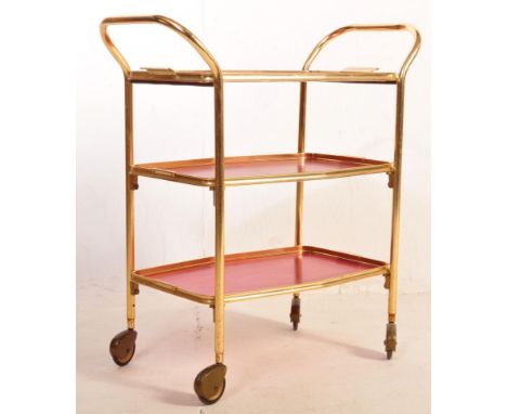 A retro vintage 20th century drinks trolley having a gilt metal tubular frame with three red tray tiers over castors. Measure