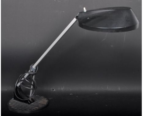 A vintage retro 20th century industrial table desk lamp having a black plastic disc shade and chrome metal arm with black cir