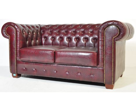 A 20th century brown leather Chesterfield style two seater sofa settee having button back back rest as well as studded button