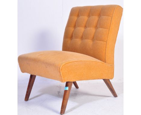 A retro vintage mid 20th century cocktail chair in the manner of Howard Keith having a buttoned back rest upholstered in yell