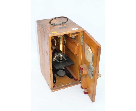 A mid 20th century lacquered brass monocular microscope by Ernst Leitz Wetzlar No. 23087 in pine case with label for Ogilvy &
