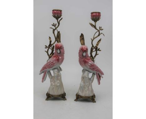 A pair of modern continental table candlesticks, each in the form of a parrot issuing a gilt metal sconce on further gilt met