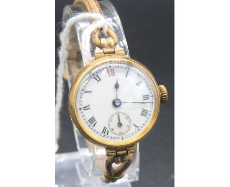 A lady's vintage 15ct gold cased manual wind wristwatch, having an unsigned white enamel dial with subsidiary seconds dial, c