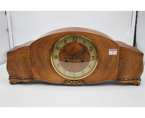 A 1950s walnut case mantel clock, the circular chapter ring with applied Arabic numerals and having an 8 day movement, striki