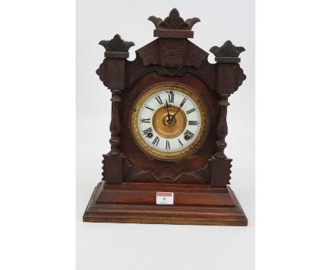 A late 19th century American walnut cased mantel clock having an enamelled chapter ring with Roman numerals, the eight day mo