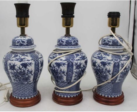 A set of three modern blue &amp; white table lamps, each of baluster form on wooden base, height 33cm (including fittings)