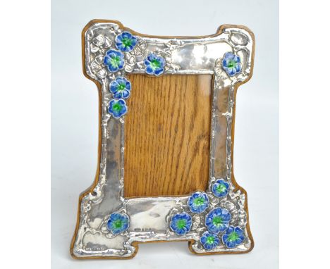 WILLIAM HAIR HASELER; an Edward VII hallmarked silver fronted Arts and Crafts shaped rectangular frame decorated with blue an