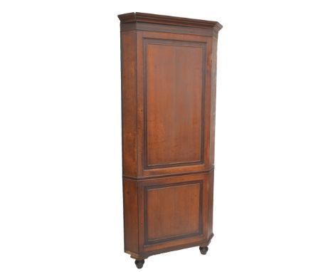 A large early Victorian oak and mahogany crossbanded freestanding flat fronted corner cupboard with moulded cornice above two