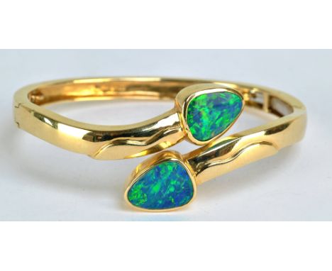 A 14ct yellow gold and simulated opal hinged snap bangle, approx 23.6g.
