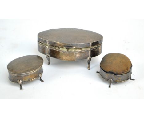 BOOTS PURE DRUG CO; a George V hallmarked silver shaped trinket box raised on four outswept feet and with floral decoration, 