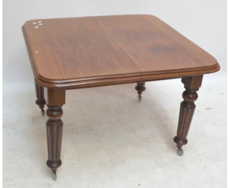 A Victorian mahogany rounded rectangular dining table with an extra leaf, on ring turned and fluted legs to casters, 142 x 98