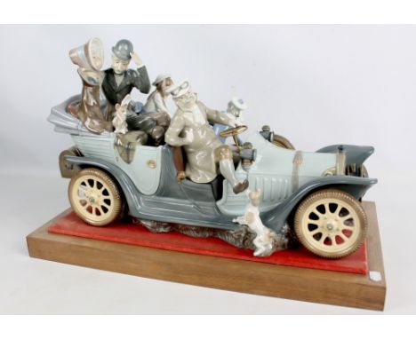 A large Lladro figure group, 1146, 'Antique Car', figures and dogs in a car including the trunk to the rear on a wooden base,
