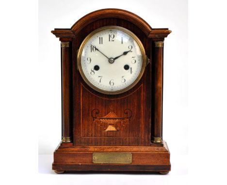 An Edwardian walnut and inlaid eight day mantel clock, the white enamel dial set with Arabic numerals, with domed top above c