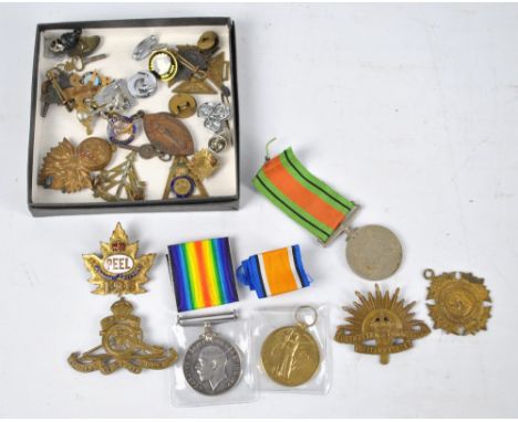 Two WWI medals and a WWII Defence medal, also a collection of various badges including Australian Commonwealth military force