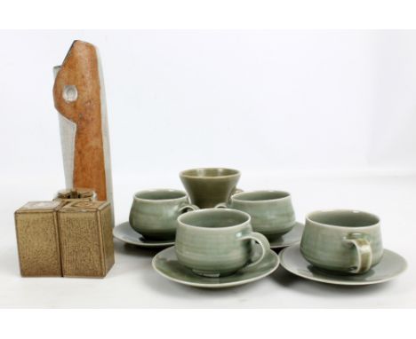 A set of four Hugo green glazed stoneware cups and saucers, all with impressed marks to base, an oatmeal glazed stoneware cru