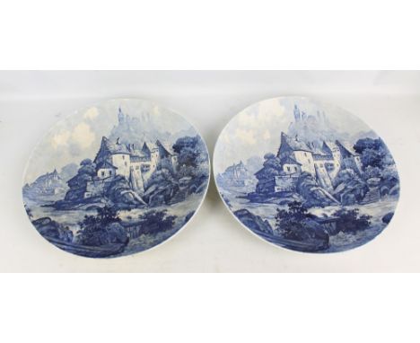 A pair of Villeroy & Boch ceramic blue transfer decorated wall mounted chargers depicting a village architectural landscape w