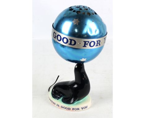 A Carltonware Guinness advertising lamp modelled as a seal balancing a ball on its nose, base and globular blue metallic shad