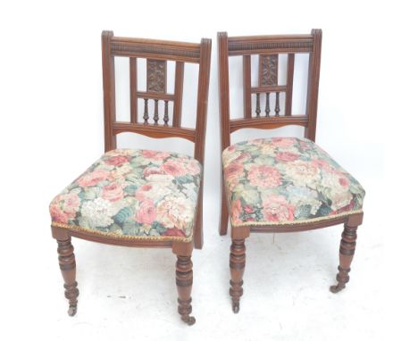 A set of six Edwardian walnut dining chairs with carved and pierced splats, padded seats and ring turned front legs (6).