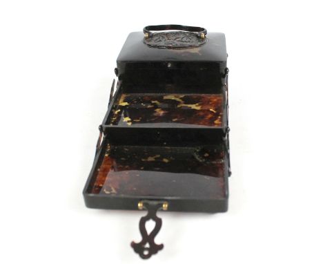 An early 20th century Chinese tortoiseshell three tier cantilever trinket box finely carved with a dragon amongst clouds to t