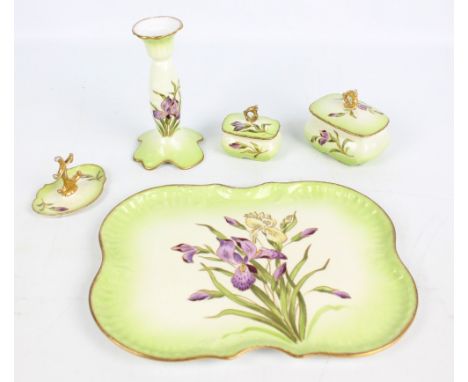 An early 20th century Continental porcelain five piece dressing table set decorated with iris motifs comprising a tray with i