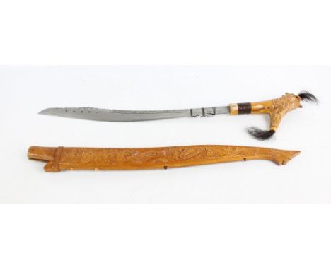 A Dayak Parang from Sarawak with decorative blade and carved scabbard, total length 80cm.