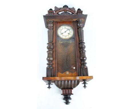 A Victorian Vienna eight day wall clock, the white enamel dial set with Arabic numerals, with carved foliate decoration and r